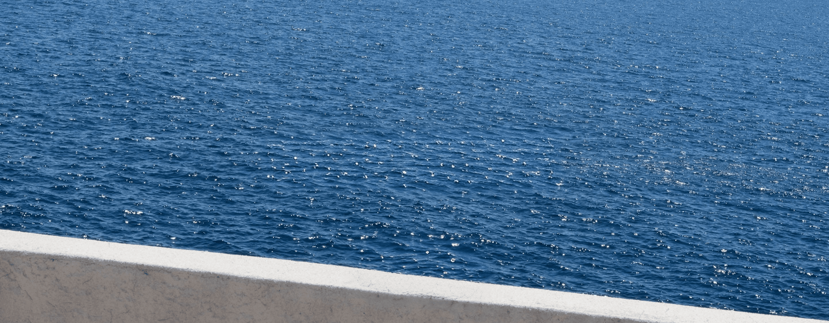 Sunlight sparkling across deep blue water.