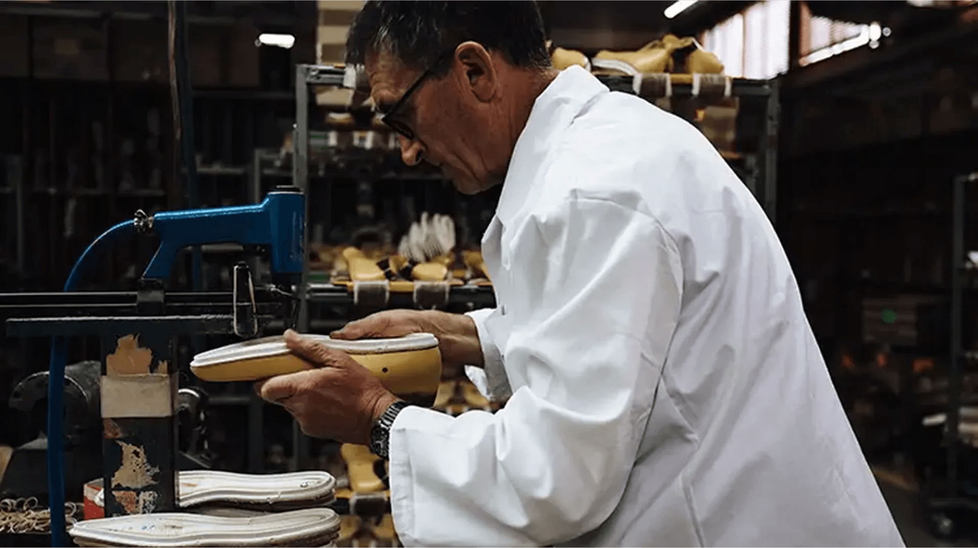 A maker working on the sole of a shoe in a workshop.
